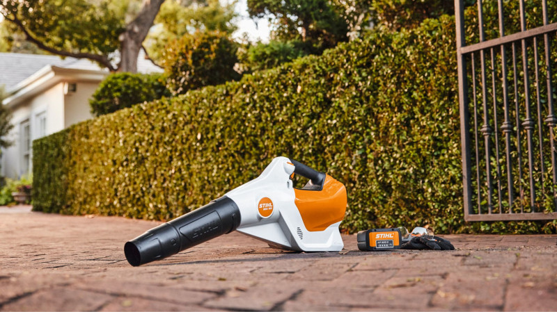 Akumulatorowa dmuchawa STIHL BGA 160 leżąca na podjeździe, gotowa do pracy z liśćmi.